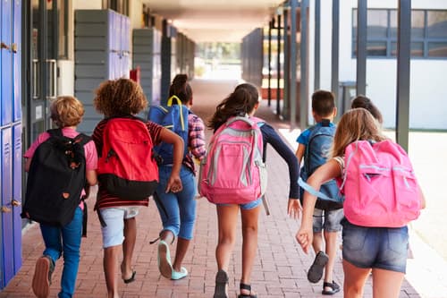 Koululaiset juoksevat käytävällä